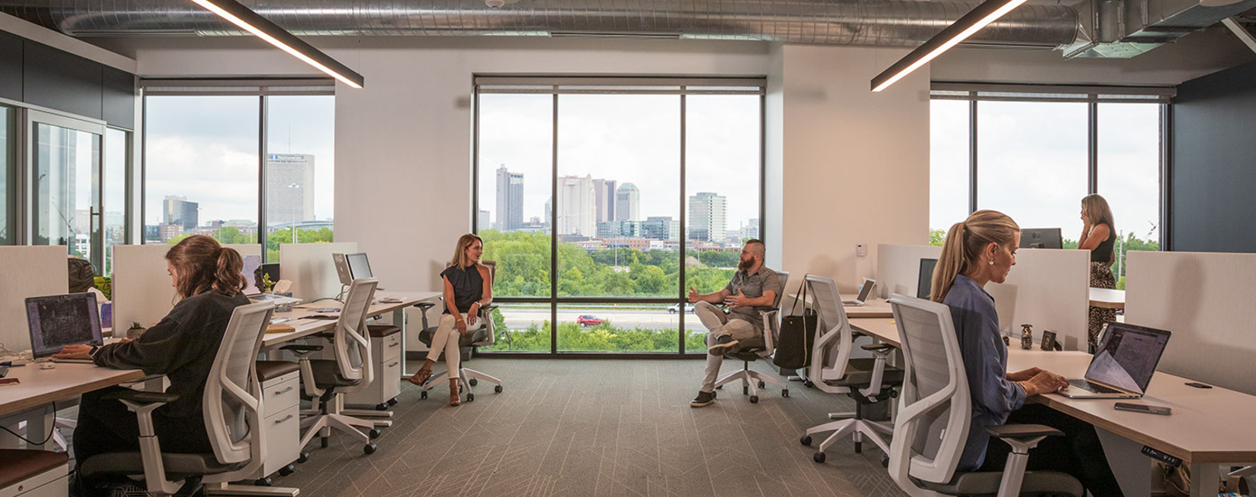 Upright team members working in the office overlooking downtown Columbus.
